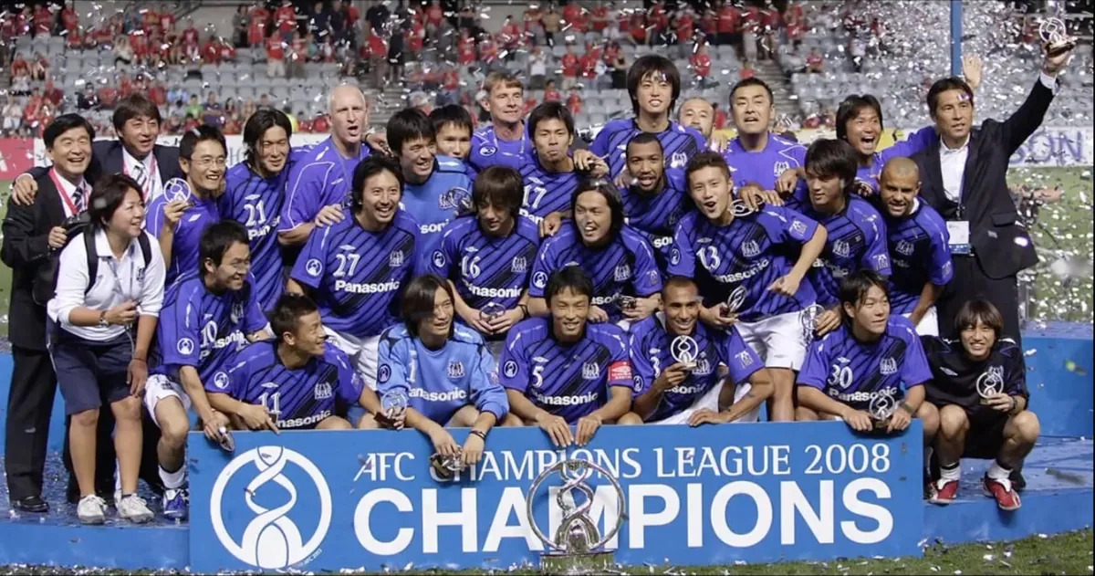AFCチャンピオンズリーグ2008優勝の看板の後ろで喜ぶガンバ大阪の選手とスタッフ