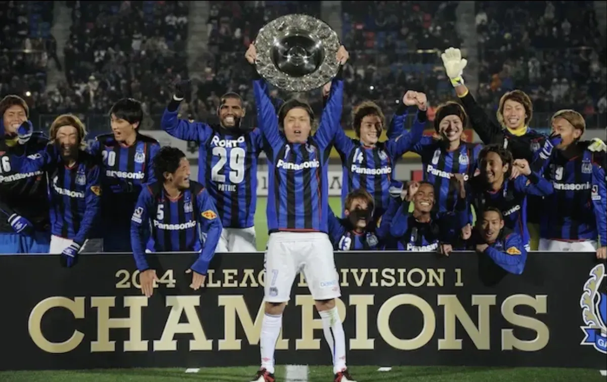 2014 J.LEAGUE DIVISION 1 CHAMPIONSの看板の前でシャーレを掲げるガンバ大阪の選手たち